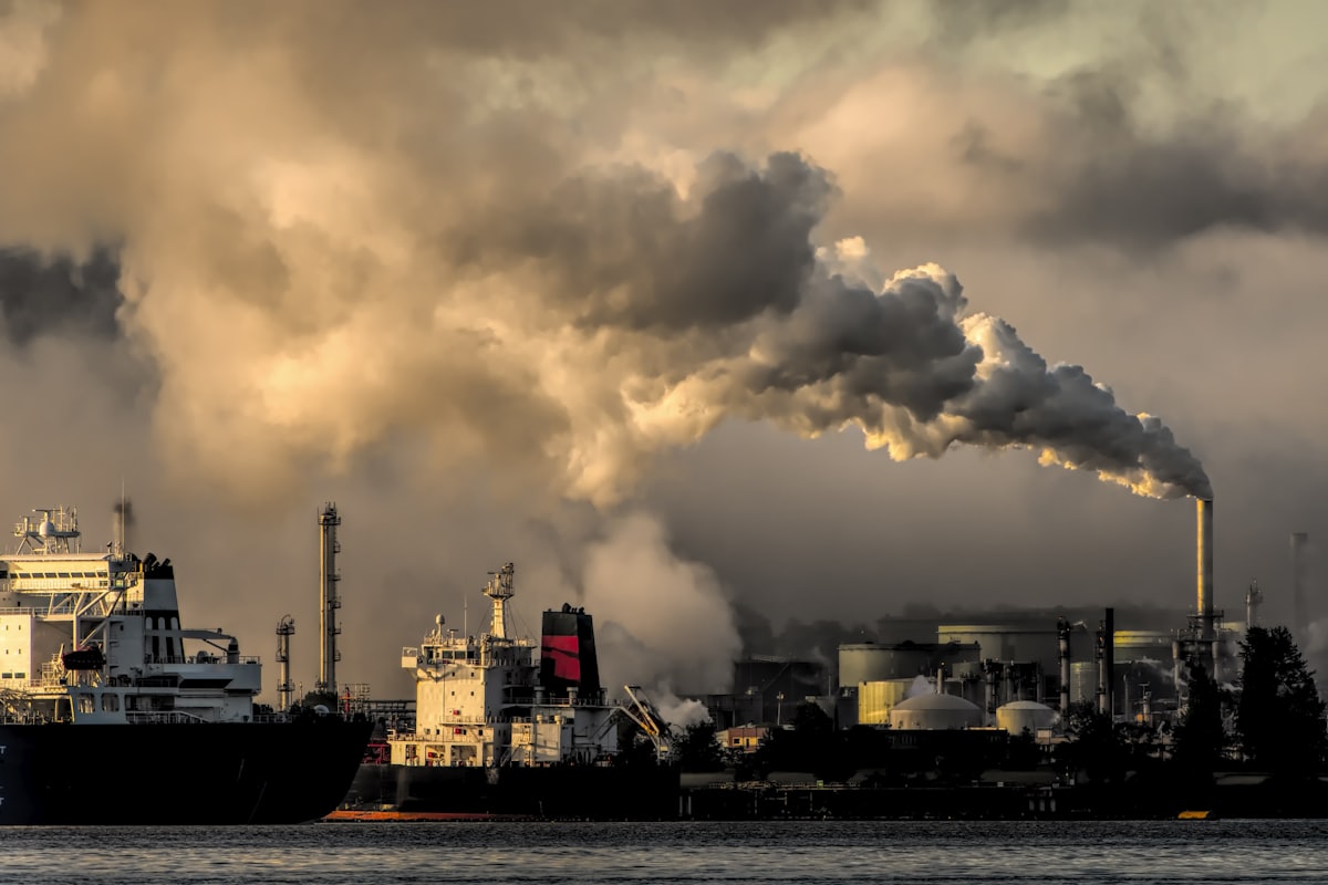 Industrial smokestacks emitting smoke at dawn, a symbol of global warming